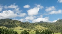 White clouds moving fast over green Tararuas mountains in New Zealand nature landscape Time lapse
