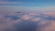 Fly above colorful clouds in sunny morning in misty foggy landscape with blue sky heaven Panoramic aerial view
