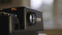 Old slide projector in a dark room switching between slides with lens refocusing