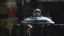 Close up of a pot of coffee brewing on the stove