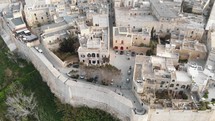 Mdina city walls and old cityscape, near the Cathedral of Saint Paul  - Aerial Fly-over slow tilt up shot