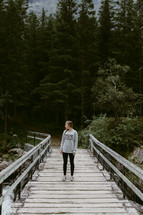 a woman standing on a wooden bridge in Norway 