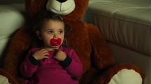 toddler watching television snuggled up with a teddy bear 