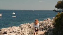Girl walking besides the sea in South of France 