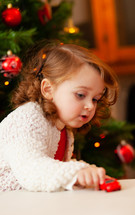 little child plays with little red toy car at Christmas 