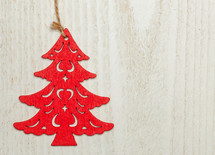 Red wooden Christmas sapling on white wood background. 
