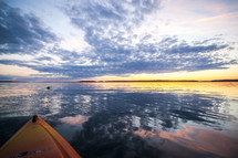 bow of a canoe on a lake at sunset 