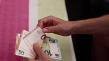 Male hands counting euro bills.