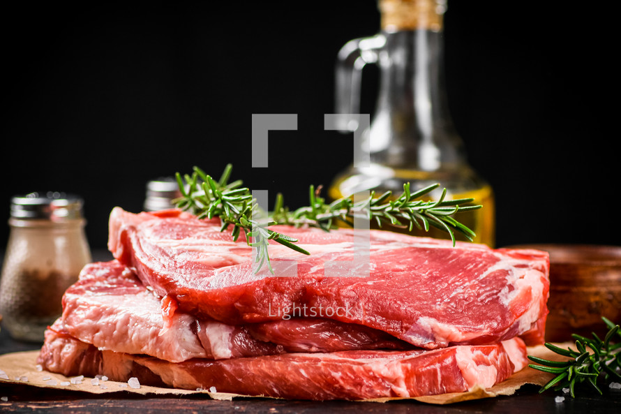 Raw pork steak on a stone board. On a black background. High quality photo