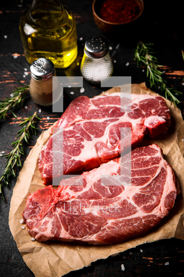 Raw pork steak on a stone board. On a black background. High quality photo