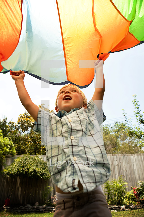 toddler boy holding a parachute 