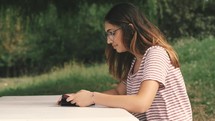 a young woman reading a Bible outdoors 