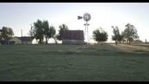 windmill and barn on a farm at sunset 