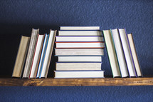 stacked books on a book shelf 