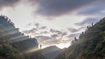 Evening sky clouds and sunbeam light moving over primeval forest in New Zealand wild nature Time lapse
