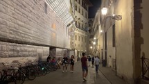 people walking narrow streets of Florence, Italy at night 