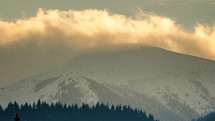 Time-lapse of cloudy sky over snowy peak in winter alps mountains nature
