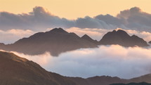 Clouds over foggy mountains landscape in sunny evening in New Zealand nature Time Lapse
