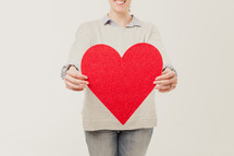 woman holding a red heart cut out 