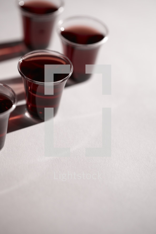 A few communion cups filled with wine isolated on white.