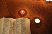 Bible and red and white votive candles