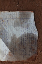 Writing on notebook paper in the dirt.