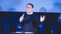 a preacher on stage with a microphone 
