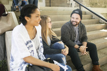 college students sitting on steps on campus 