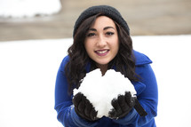 a woman holding a large snowball 