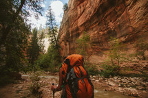 a woman backpacking near a stream 