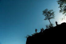 silhouettes standing at the edge of a cliff in Kenya 
