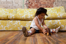 Asian toddler girl on the floor with a toy car 