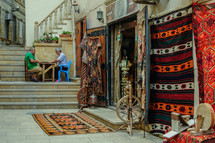 store front with rugs hanging outside. Handmade crafts and carpets in Baku, Azerbaijan.