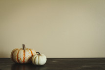 two pumpkins on a wood table