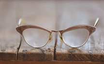 Eye glasses on a wooden table.
