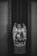 Indoor statue of a kneeling angel.