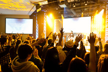 A group of people with hands raised worship service crowd