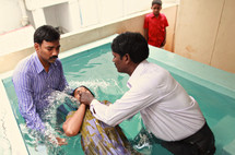 woman being dunked during a Baptism in India