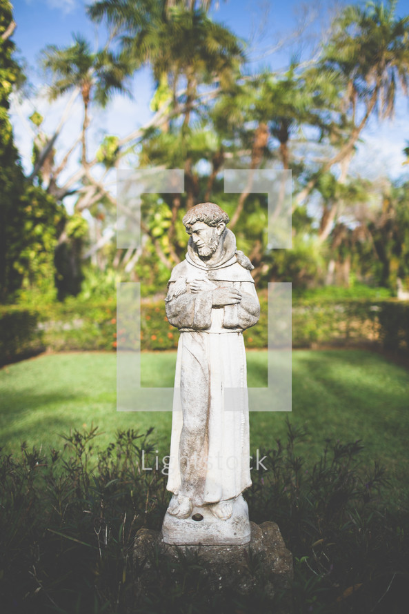 Statue of St. Francis of Assisi in a garden.