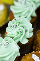 Chocolate cupcakes with green frosting and silver beads