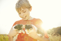 A boy holding kittens.