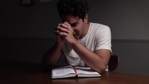 a man reading a Bible and praying 