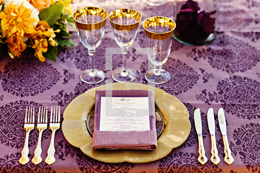 Formal dinner setting at table purple gold orange