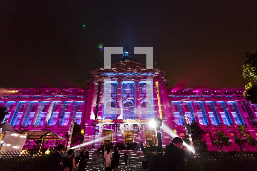 A large building lit by spotlights celebration party event lighting