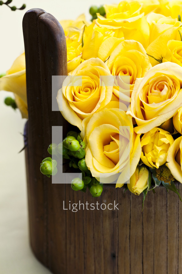 Flower arrangement yellow roses in wood vase basket