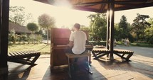 man playing a piano outdoors 