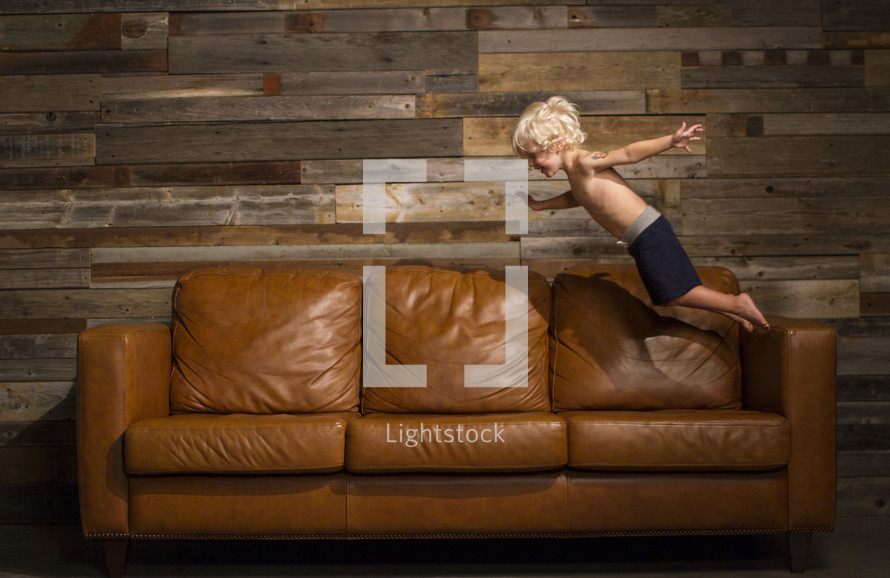 a child jumping onto a couch 