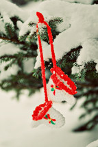 knitted mittens hanging on a snowy tree 
