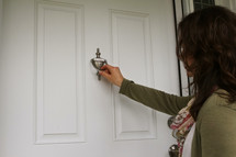 a woman knocking on a front door 