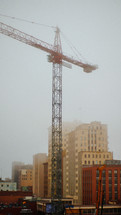 construction crane over a foggy city 